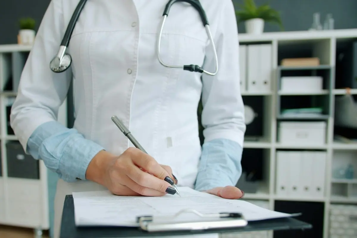 Dokter mencatat hasil pemeriksaan